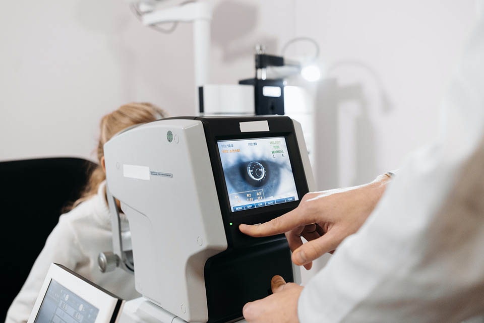 customeyes-cataracts-symptoms-causes-prevention Image of optometrist executing eye exam